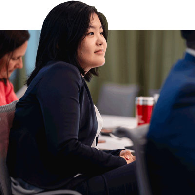 MBA female student with suit on listening to speaker