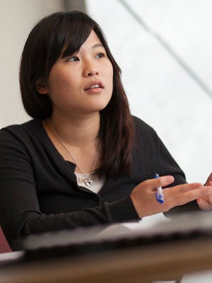 Hospitality Student speaking in a classroom while holding a pen.
