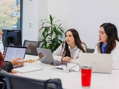 Three students work together around a table at Cornell Tech.