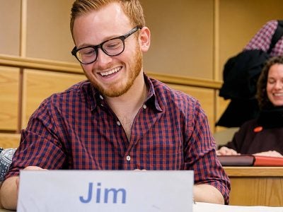 Smiling MBA student reviewing class notes.