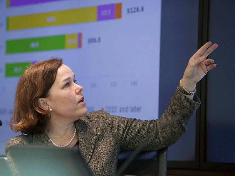 woman teaching with graphs behind her