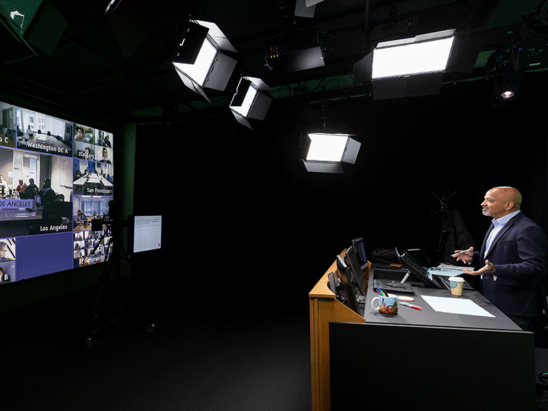 A faculty member teaching a live virtual course online in our studio.