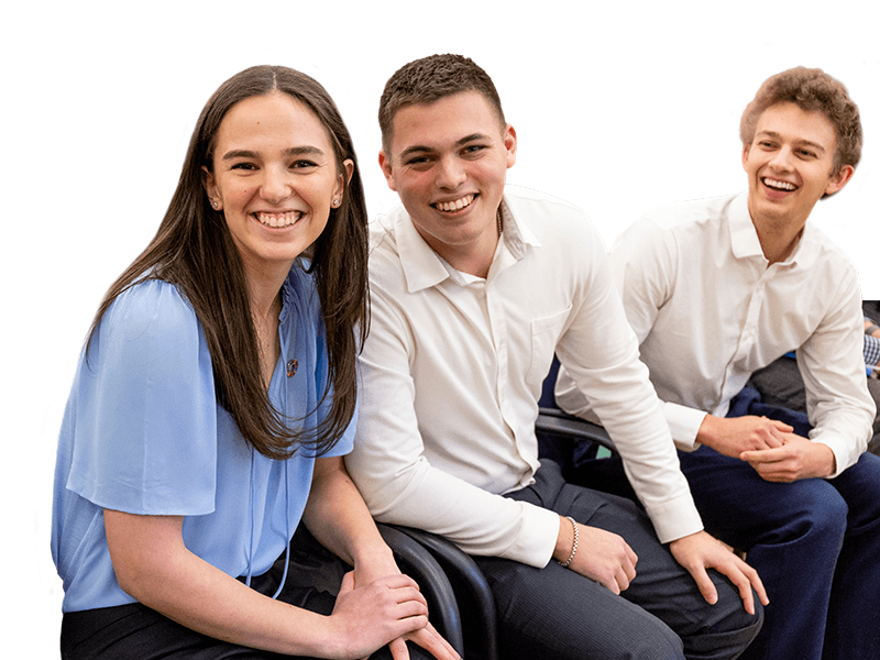 Three students smiling and laughing at the Dyson Grand Challenges Pitch Competition.