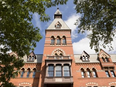 Sage Hall, a brick building, looking up toward a blue sky..