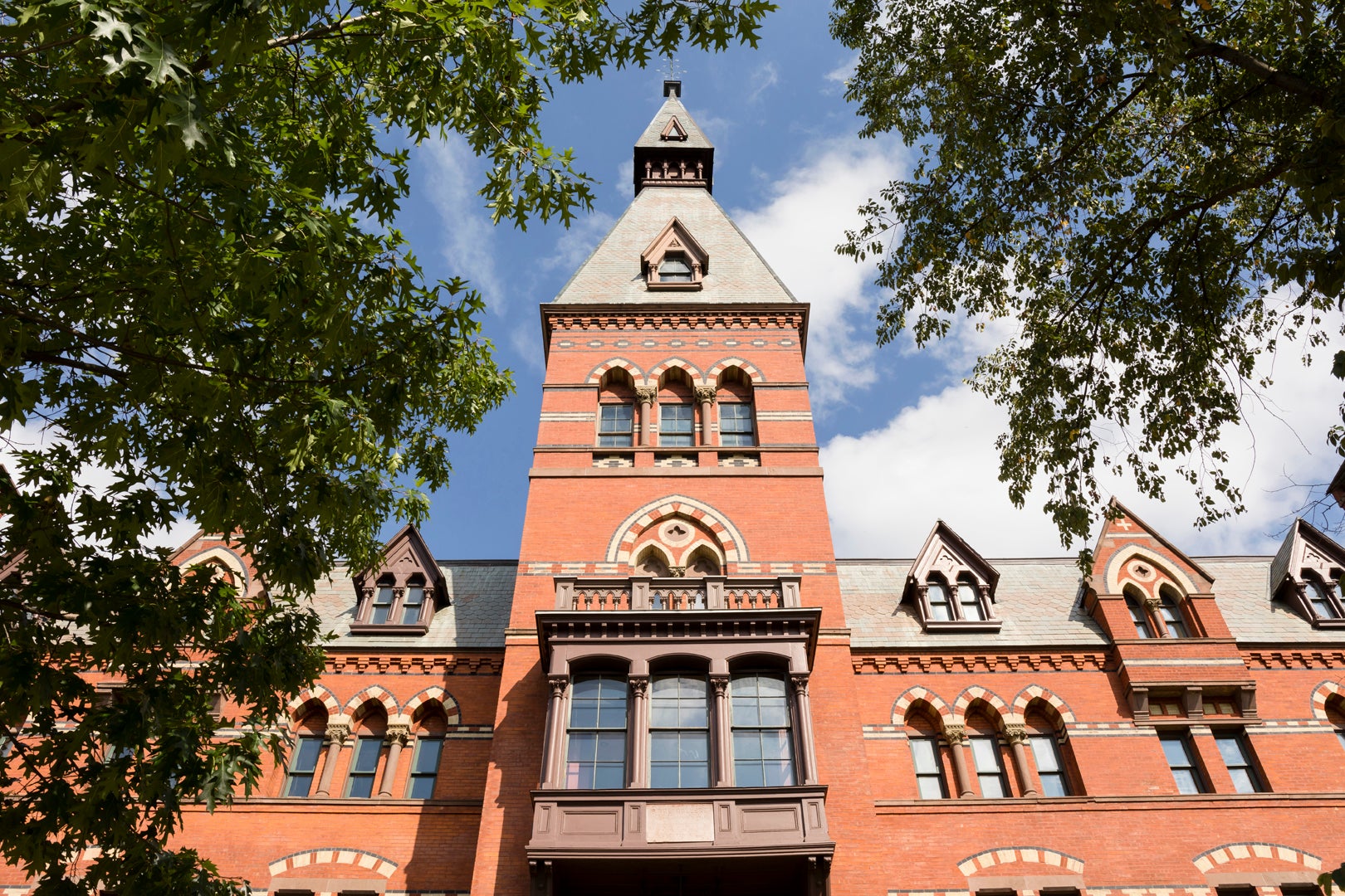 Sage Hall, a brick building, looking up toward a blue sky..