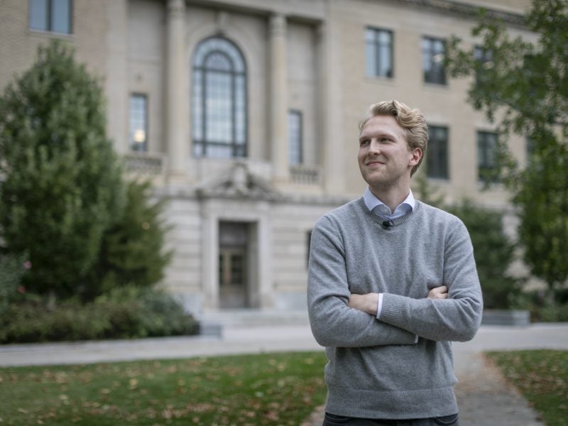 Cornell MPS AEM student stands in front of Warren Hall.