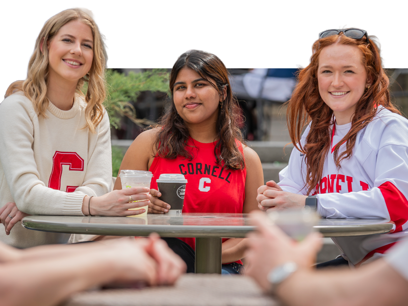 Three women in Cornell sweaters at Collegetown Bagels.