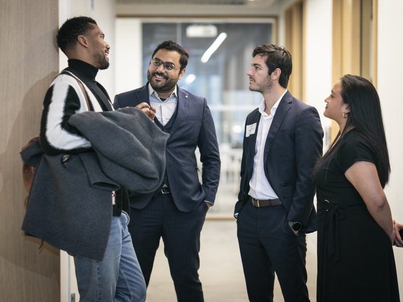 Cornell graduate students standing in the hallway after an evening event.
