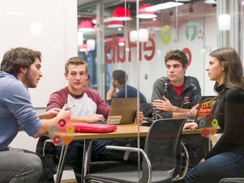 four students sitting at eHub office discussing a project