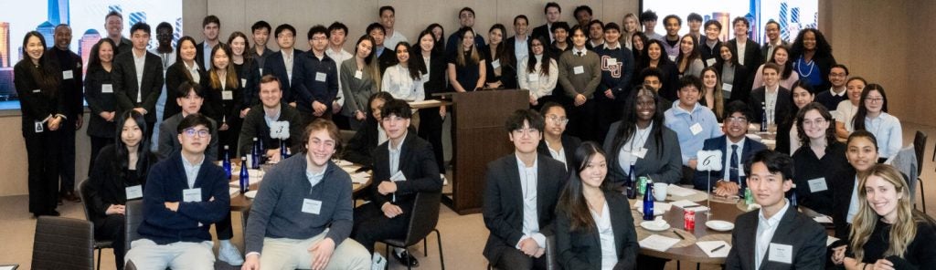 Accelerator Scholars and mentors sit together in a classroom group photo smiling