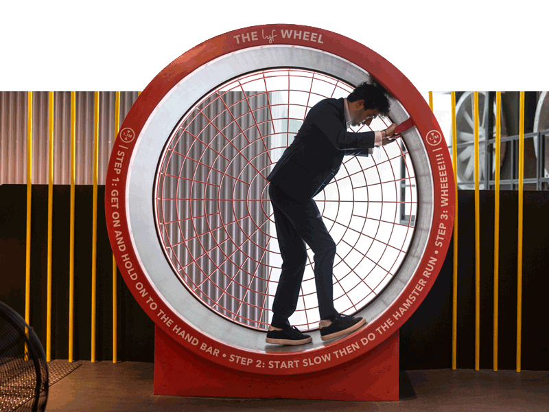 Student on a Real Estate TREK to Singapore inside a red turning piston like wheel