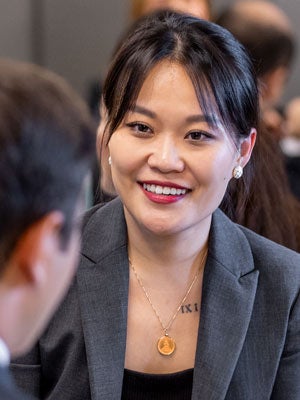 H1-B student smiles during a conversation at a professional event