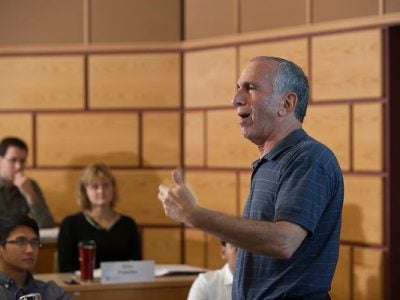 Bob Libby speaks in front of a classroom of students.
