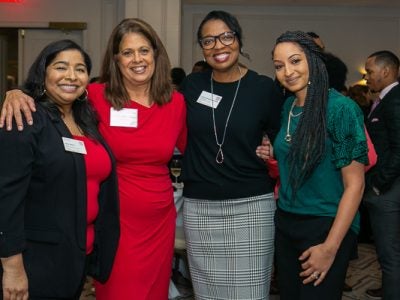 Four women pose for a photo at the 20th anniversary event