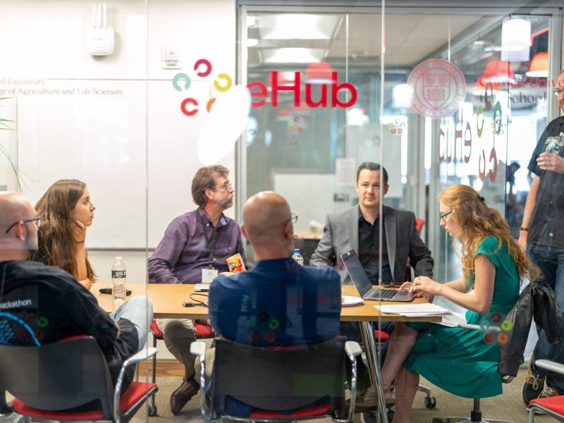 Jess Petitt '05 (standing) meets with his team of mentors during the 2019 Hilton Hospitality Hackathon.