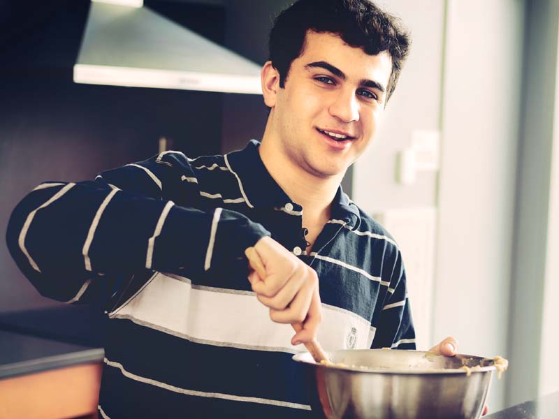 Hotelie ('26) and teen chef Matthew Merril bakes blondies in the Ruth Bader Ginsberg Hall Kitchen.