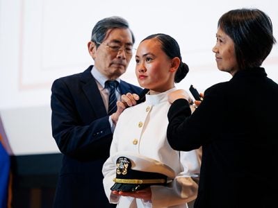 Rose Jou being pinned by her parents at the Cornell University ROTC Tri-Service Commissioning Ceremony, held May 23 in Statler Auditorium.