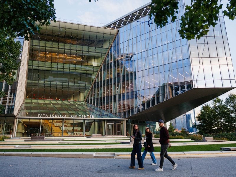 Three students walk past the Tata Innovation Center in NYC