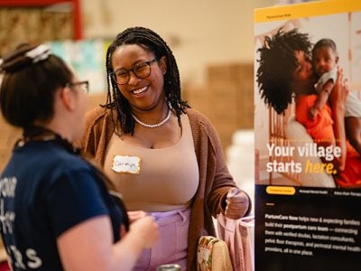 Carmyn Polk presents PartumCare Now to an attendee of the family resources fair