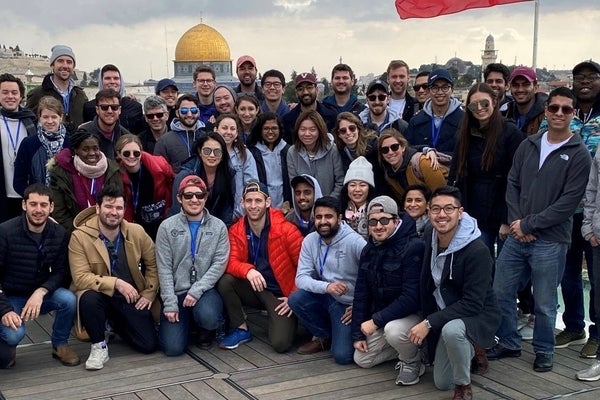 The group poses for a photo with the gold Dome of the Rock in the background