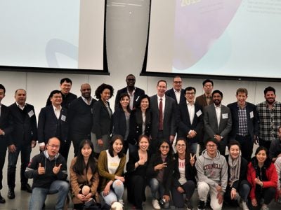 Large group photo at the front of the lecture hall