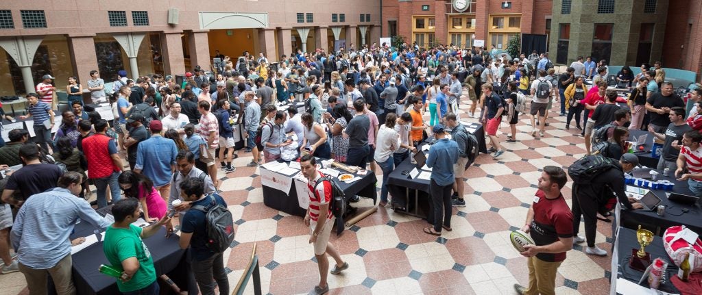 A clubs and associations demonstration and recruitment fair within the Dyson Atrium of Sage Hall for Cornell MBA students.
