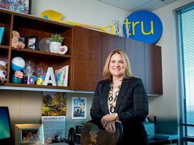Photo of Alex Jaritz in her Tru by Hilton office