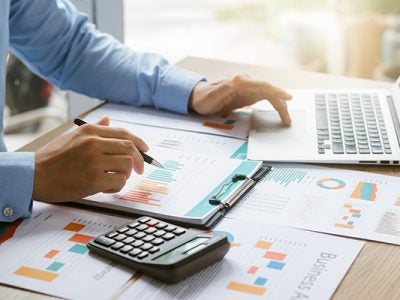 Concept of business growth and financial investment, executives use laptop computers to analyze sales data and economic growth graphs, business planning and strategy.