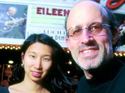 photo of Barry Massarsky and Nari Matsuura standing in front of a theatre marquis.