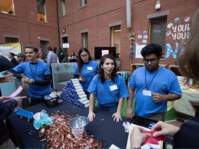 Students standing at table in matching shirts promoting Nair products at Sage Hall