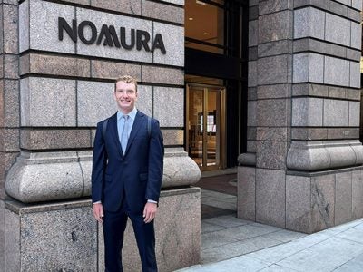 Ben Roberts posing in front of Nomura office building.