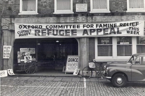 A black and white photo featuring a banner saying, &ldquo;Oxford Committee for Famine Relief; Refugee Appeal&rdquo;, Oxfam&rsquo;s namesake