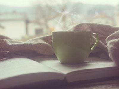 Photograph of a book and cup of coffee for winter reading list