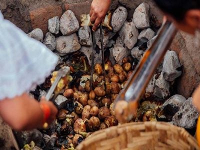 People Cooking Potatoes on Coals