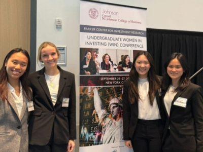 Grace Ou ‘27, Lucille Ley ’27, Amber Li ‘27, and Victoria Gong ‘25 pose by the 2024 Undergraduate Women in Investing Conference banner.
