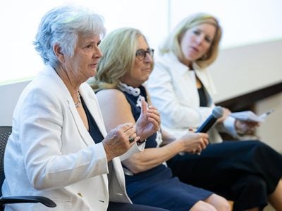 3 women sitting side by side with one speaking and gesturing.