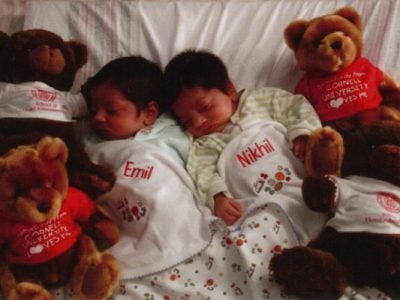 Emil and Nikhil as infants surrounded by Cornell bears