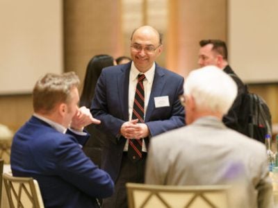 Vishal Gaur stands with two conference attendees.