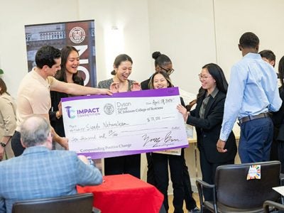 Image of Zachary Burr presenting Team Siendo Naturaleza with the grand prize check