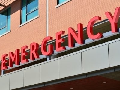 Building with written sign saying emergency in red.