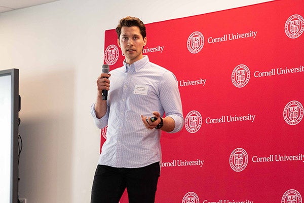 Evan Trofimchuk standing and speaking into a microphone.