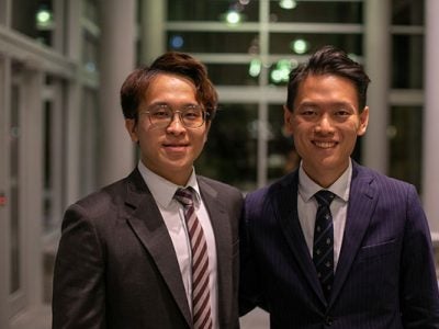Two men dressed in suits standing side by side.