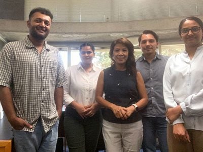 a group of 3 men and 2 women standing side by side in an office setting.