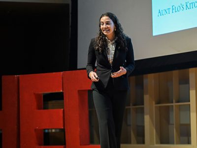A woman dressed in business attire speaking on stage.