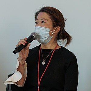 photo of Helen Ye holding a mic and speaking