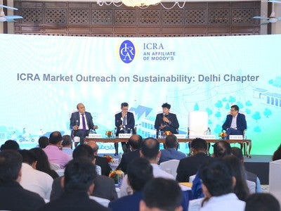 Pinaki Bhattacharyya sitting on stage with a panel in front of a slide stating ICRA Market Outreach on Sustainability.
