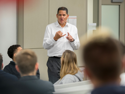 Reggie addresses students in the front of a classroom