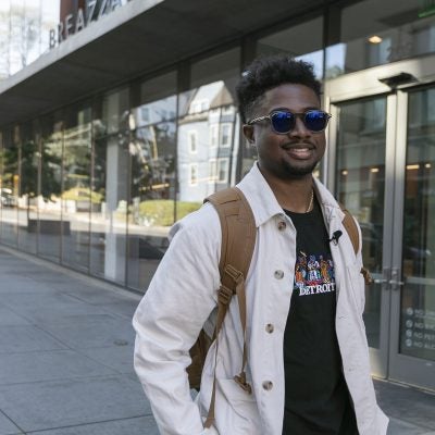 MBA student walking in front of Breazzano Building, Ithaca NY