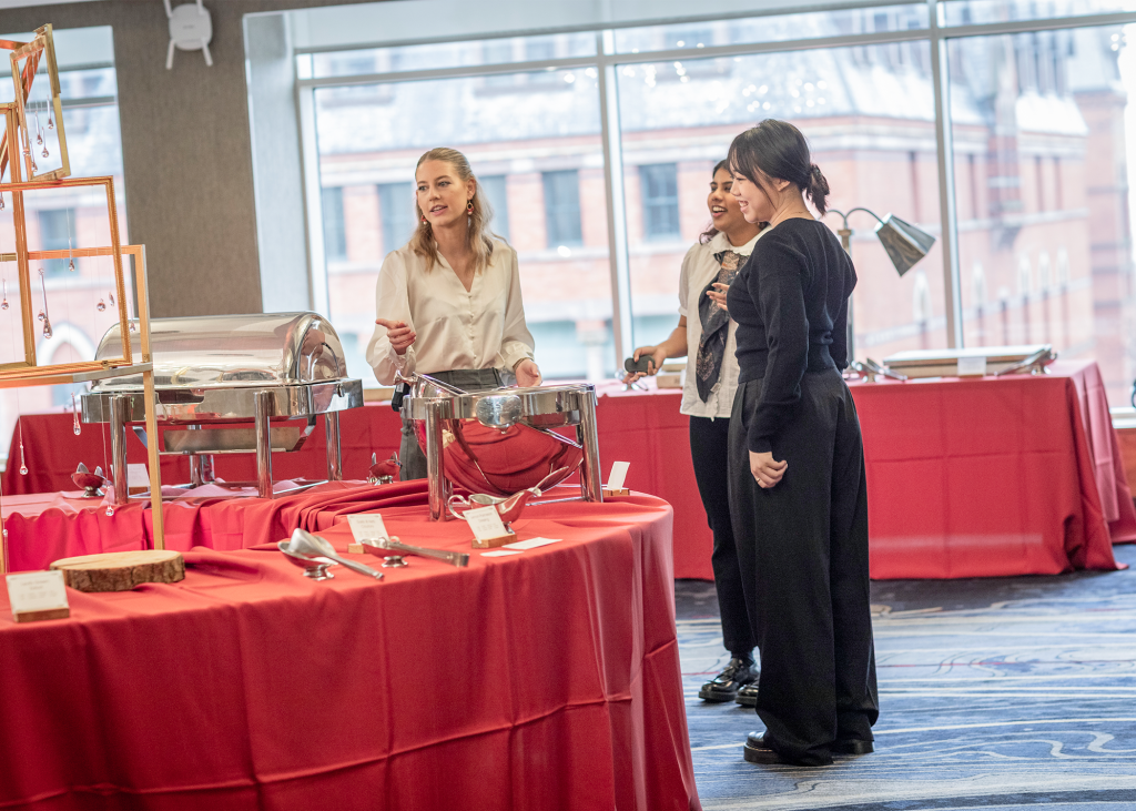Three Nolan students setting up indoor event tables