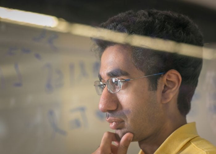 Person studying data written on a glass board.